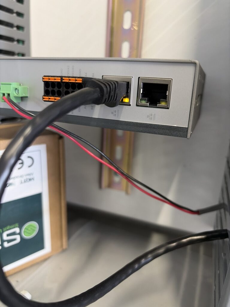 Cellular hub installed at the top of a control cabinet above a PLC and network switch